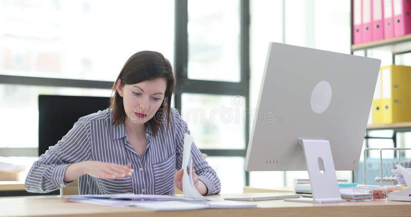 Woman working on computer and documents in office stock video