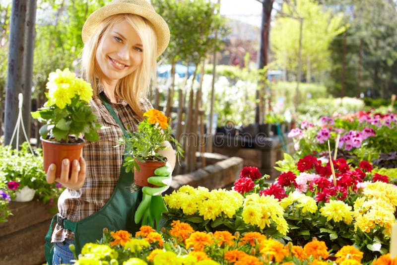 Woman working with flowers at a greenhouse.