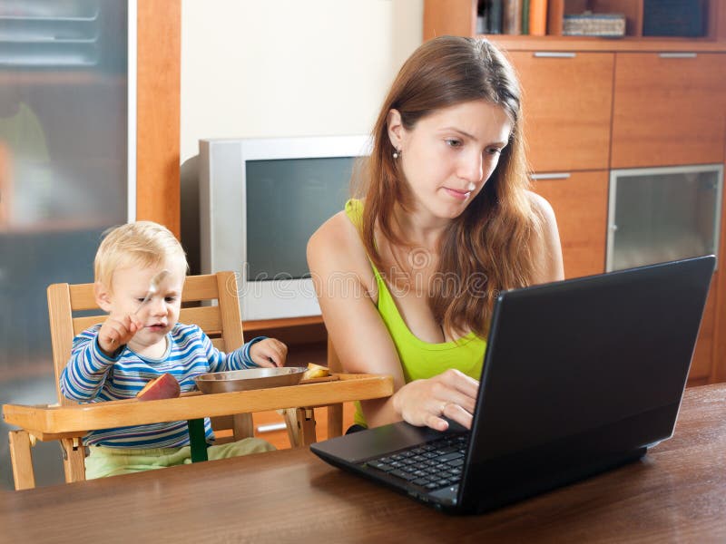 Woman working with laptop and baby