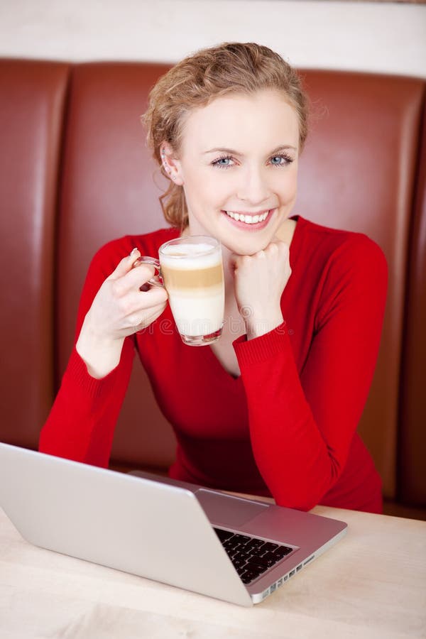 Woman working with laptop while having coffee break royalty free stock photo