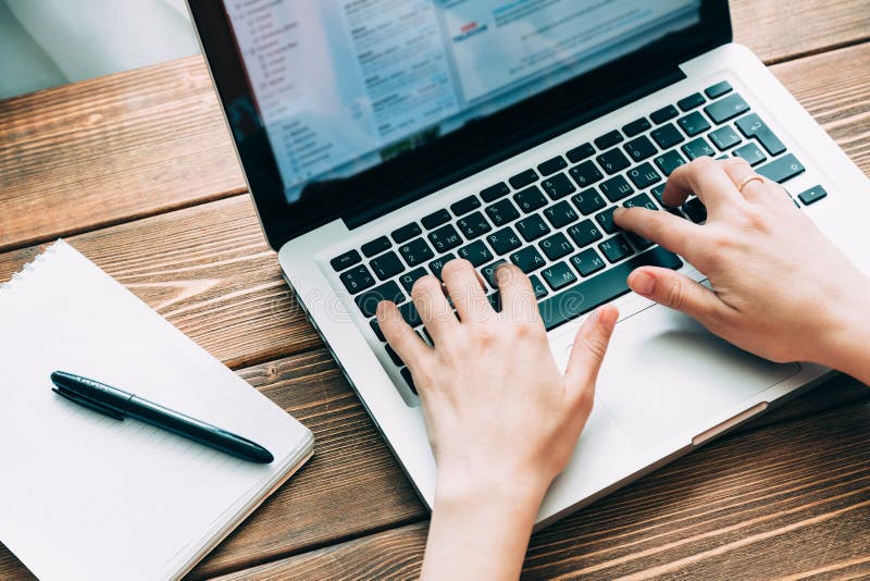 Woman working with laptop placed on wooden desk stock images