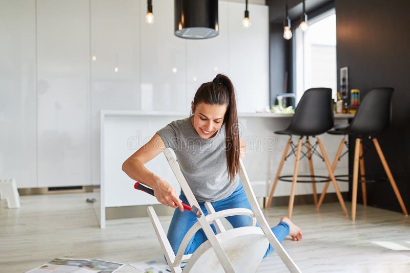 Woman working up a chair as upcycling as a handyman