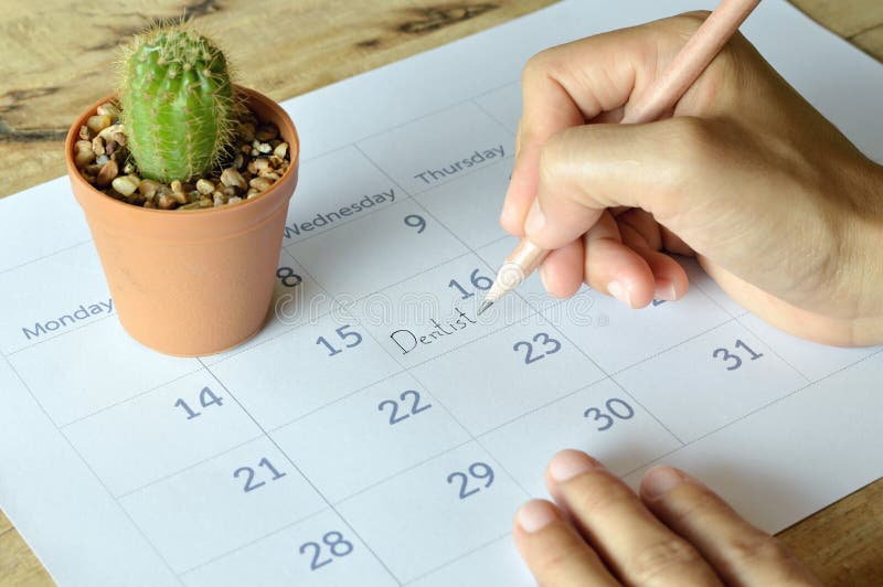 Woman write dentist appointment in calendar planner stock photography