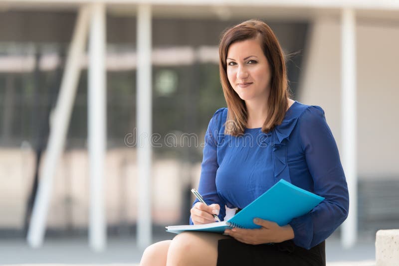Woman writing on in a blue book stock photography Woman writing on in a blue book stock photography