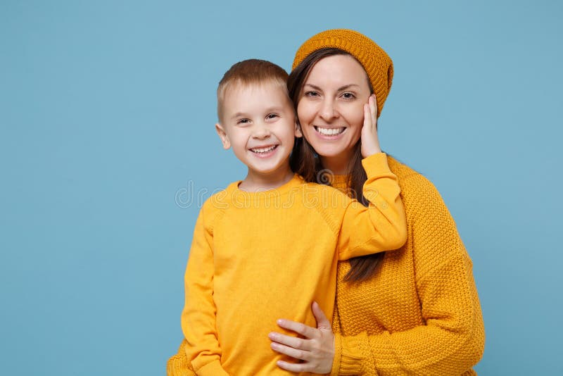 Woman in yellow clothes have fun posing with cute child baby boy 4-5 years old. Mommy little kid son isolated on blue