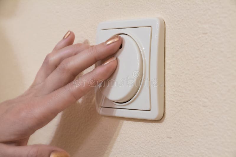 Womans hand with finger on light switch