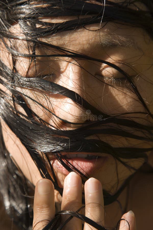 Close-up of mid-adult Asian female's face with wet hair. Close-up of mid-adult Asian female's face with wet hair.