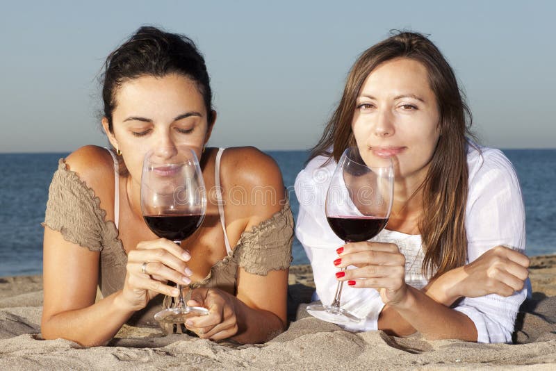 Women on the beach with red wine