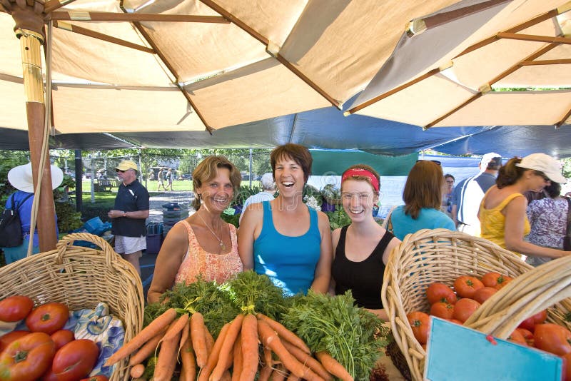 Women Behind Vegetables Smiling - Horizontal stock photo Women Behind Vegetables Smiling - Horizontal stock photo