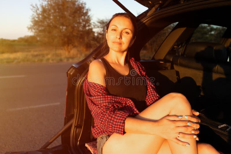 Happy Beautiful Girl Sitting in the Trunk of Car and Enjoying Sunset on ...