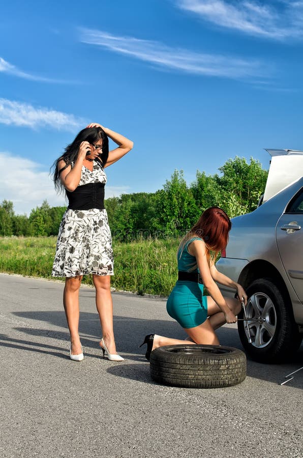 Girls changing a tire. stock photo. Image of road, help 25406660