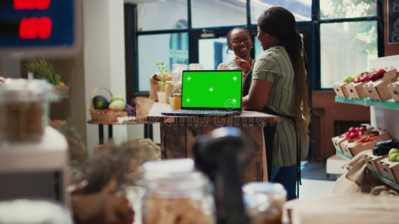 Women chats about products next to laptop with greenscreen