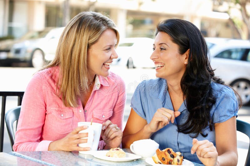 Mujer charlando a través de café a pasteles divirtiéndose.