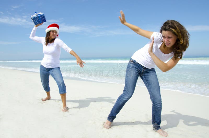 Women Christmas Holiday Fun with Present at Beach Stock Photo Image