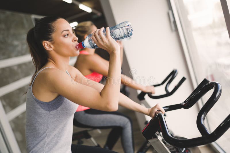 Women cycling in gym during fitness class stock photography Women cycling in gym during fitness class stock photography