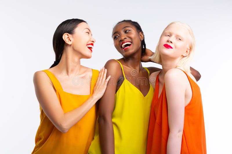 Women with different skin color wearing bright colorful clothes. Colorful clothes. Beaming cheerful women with different skin color wearing bright colorful royalty free stock images Women with different skin color wearing bright colorful clothes. Colorful clothes. Beaming cheerful women with different skin color wearing bright colorful royalty free stock images