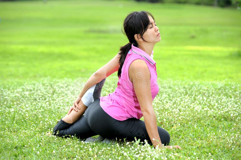 Women doing Yoga in park.