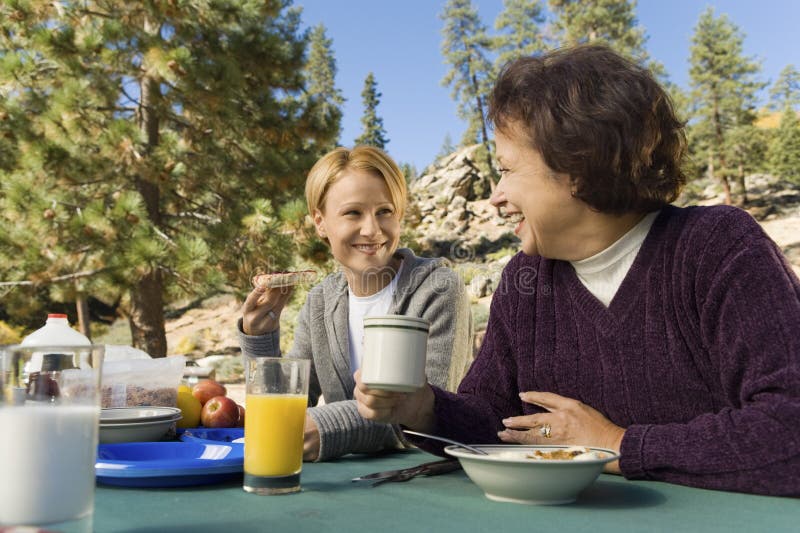 Women eating at picnic table in campground