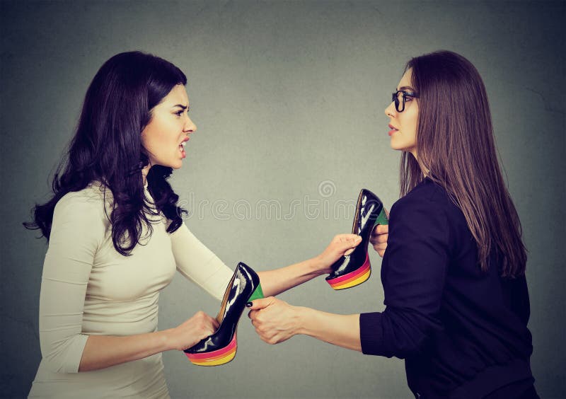 Beautiful women fighting tearing pulling apart shoes