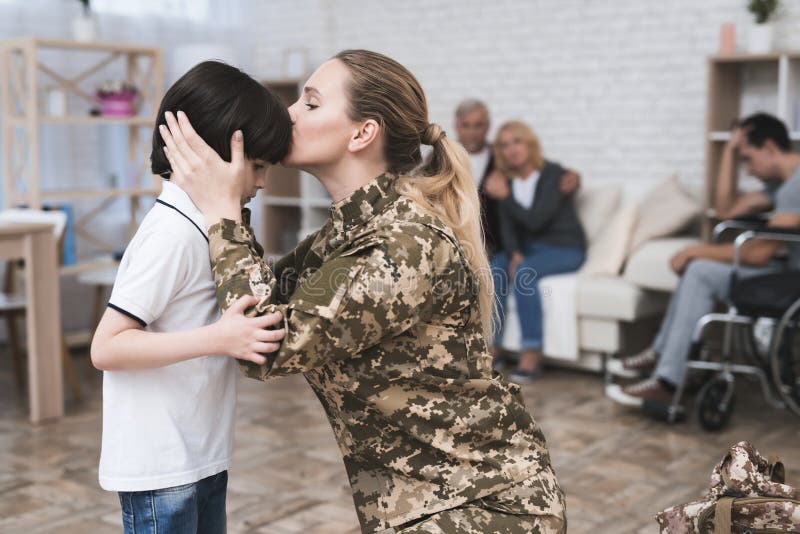 A women goes to military service. She says goodbye to her family and her parents. They are sad and embrace. She is talking to her young son. A women goes to military service. She says goodbye to her family and her parents. They are sad and embrace. She is talking to her young son.