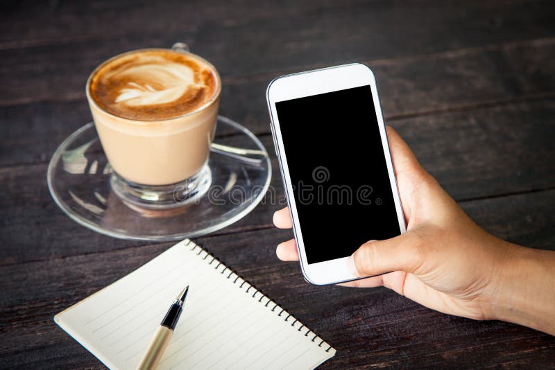 Women hand using smartphone,cellphone,tablet over wooden table