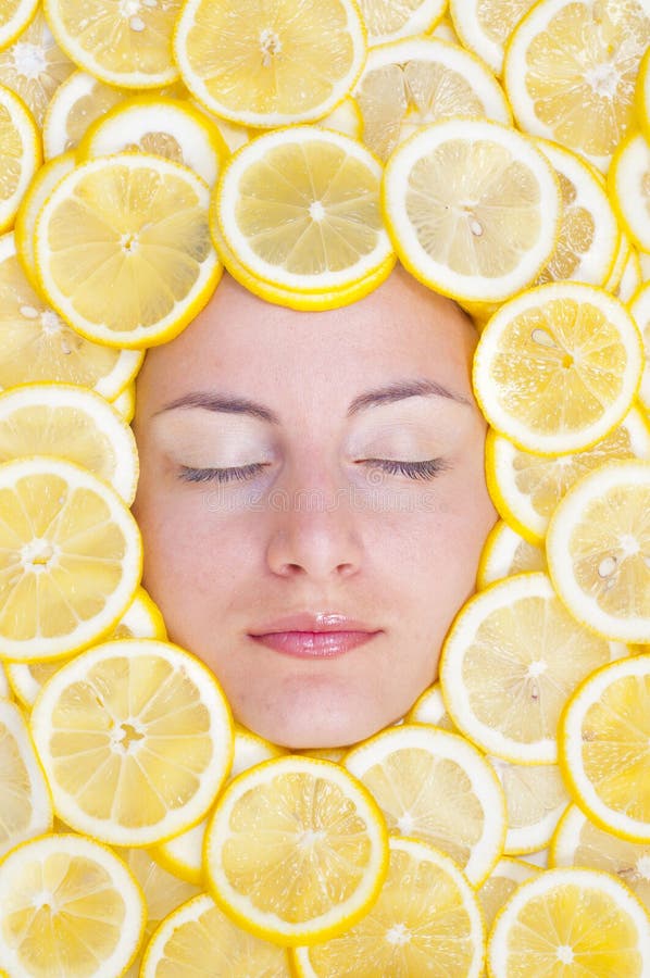 Le donne con molti limoni sul viso.