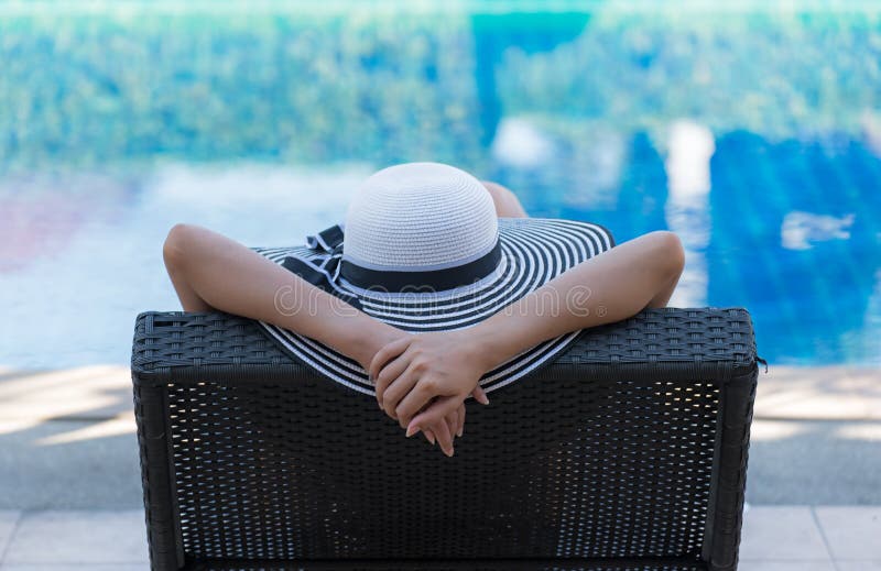 Women lifestyle relaxing near luxury swimming pool sunbath, summer day at the beach resort in the hotel. Concept Summer