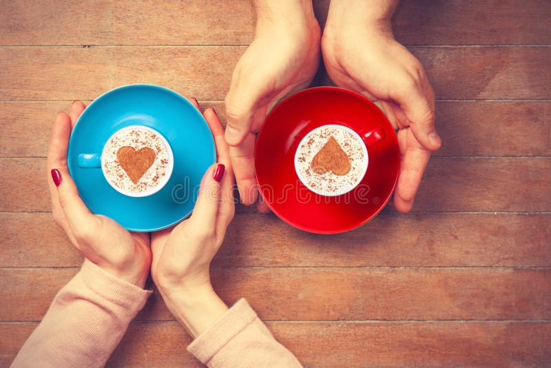 Women and man holding cups of coffee