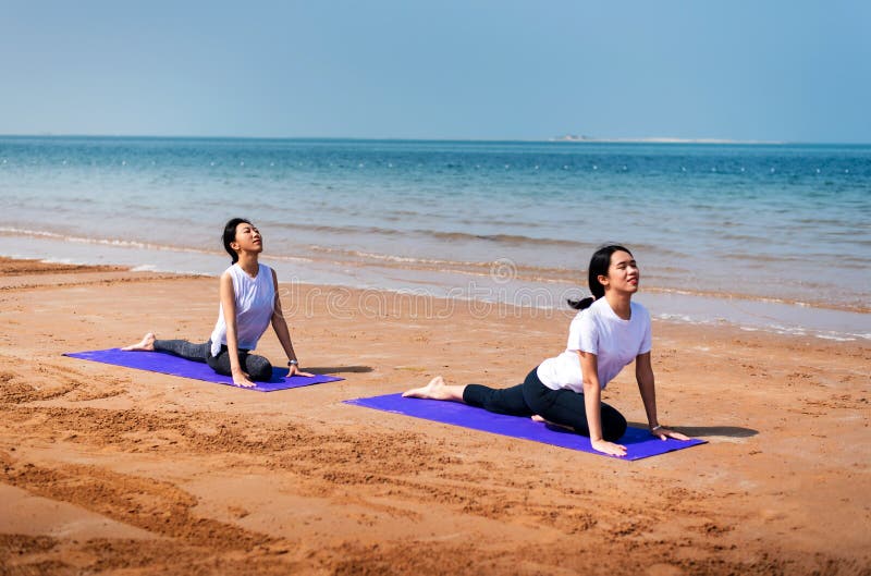 Women Practicing Camel Yoga Pose on the Beach Stock Image Image of
