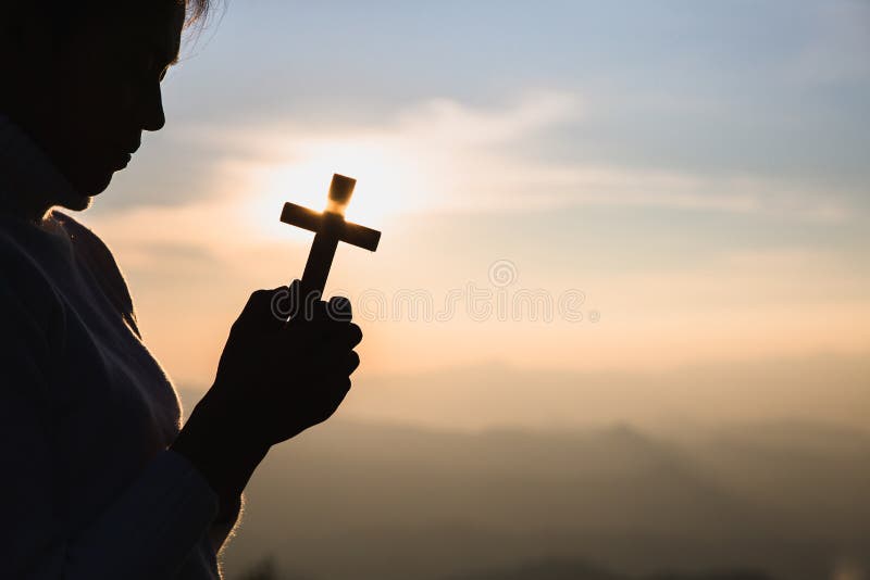 A women is praying to God on the mountain. Praying hands with faith in religion and belief in God on blessing background. Power of