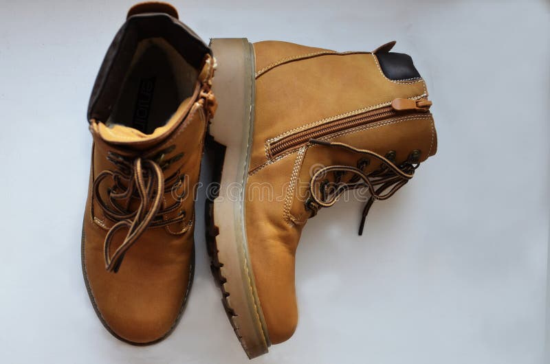 Women`s, brown shoes, half-boots, on a white background. One is standing, the other has fallen. The view from the top. Shoes with laces