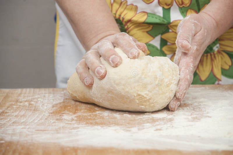 Women's hands preparing fresh yeast dough on wooden table. Raw fresh yeast dough stock images, royalty-free photos and pictures