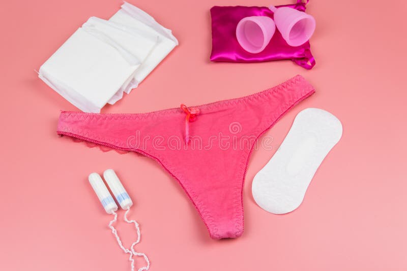 Women`s Panties With Menstrual Cups Sanitary Pads And Tampons On Pastel Pink Background Top