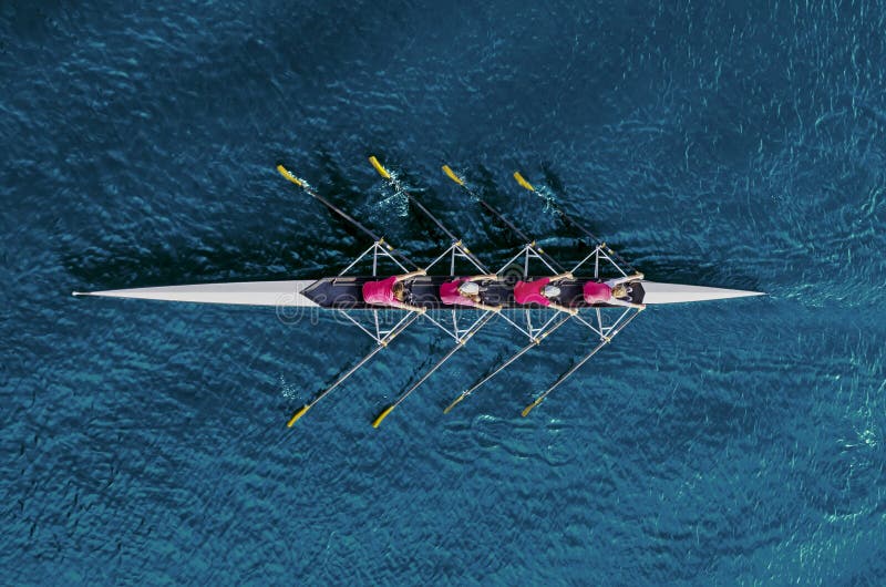 Women`s rowing team on blue water, top view