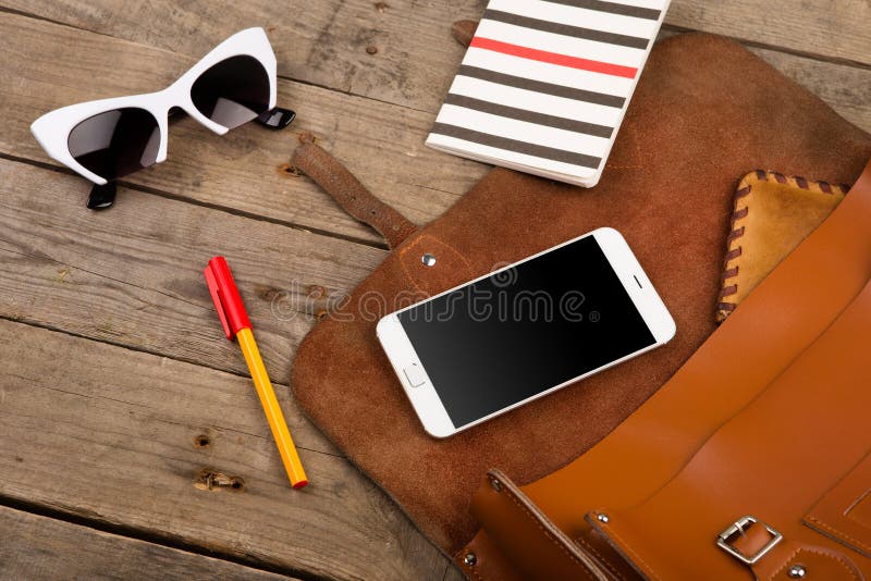 women set with bag, smart phone, sunglasses, notepad, pen and purse on brown wooden desk royalty free stock photography women set with bag, smart phone, sunglasses, notepad, pen and purse on brown wooden desk royalty free stock photography