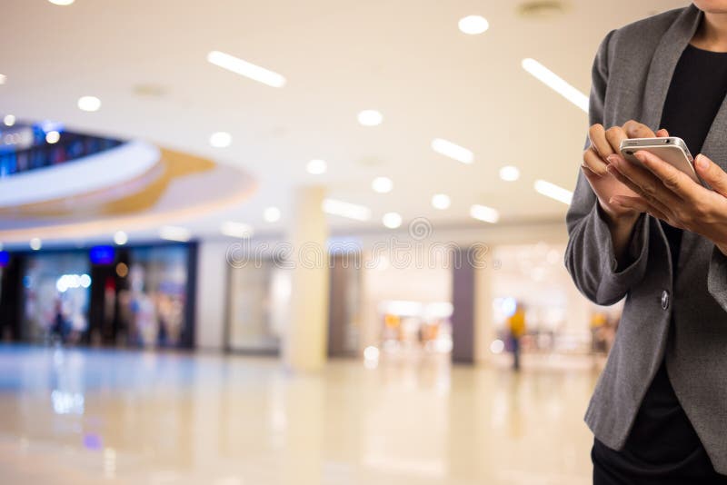 Women in Shopping Mall Using Mobile Phone. Stock Photo Image of shop