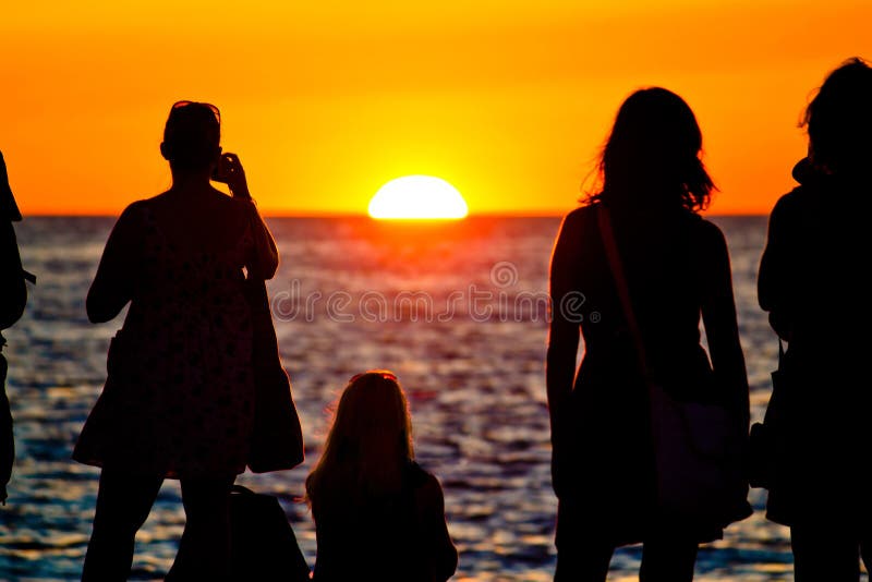 Women silhouette watching sunset on sea coast stock images