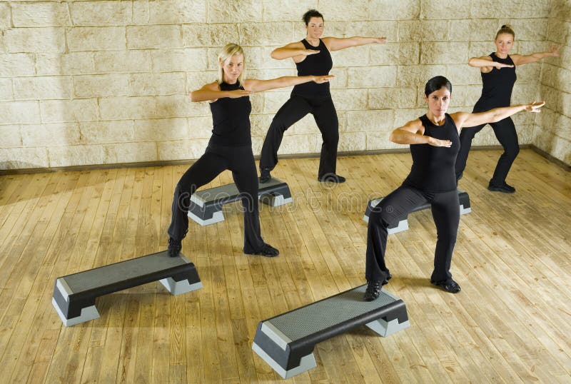 A group of women exercising in the fitness club. Looking at camera. High angle view. A group of women exercising in the fitness club. Looking at camera. High angle view.