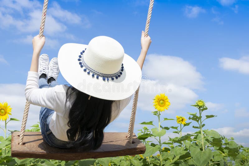 Women tourists are enjoying the beautiful nature, are playing wooden swings