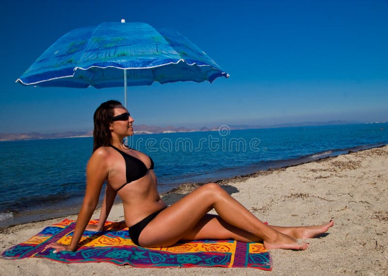 Women under umbrella on beach sun