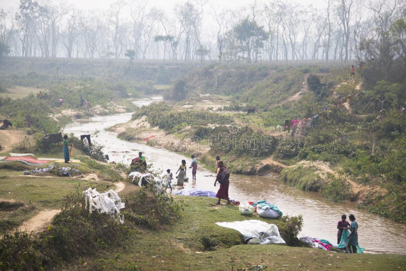 SRIMANGAL, BANGLADESH - FEBRUARY 2017: Women washing clothes in the river in Srimangal in Bangladesh. SRIMANGAL, BANGLADESH - FEBRUARY 2017: Women washing clothes in the river in Srimangal in Bangladesh