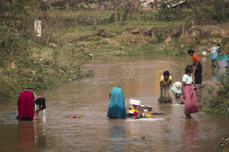 SRIMANGAL, BANGLADESH - FEBRUARY 2017: Women washing clothes in the river in Srimangal in Bangladesh. SRIMANGAL, BANGLADESH - FEBRUARY 2017: Women washing clothes in the river in Srimangal in Bangladesh