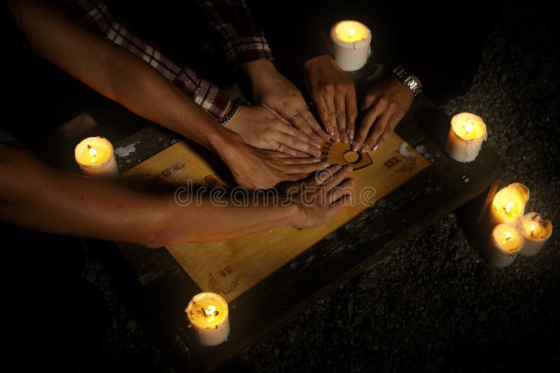 Women witches with spiritual board ouija summoning ghosts