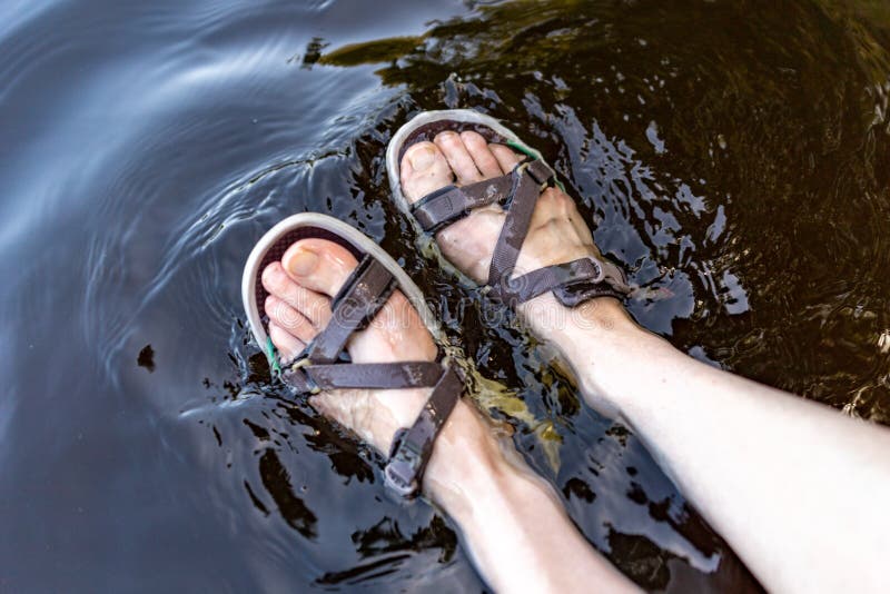 Women& x27;s legs in sandals soaked in the lake. Feet immersed in the lake. Women& x27;s legs in sandals soaked in the lake. Feet immersed in the lake