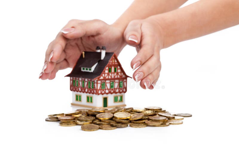 Womens hands protect miniature house with coins