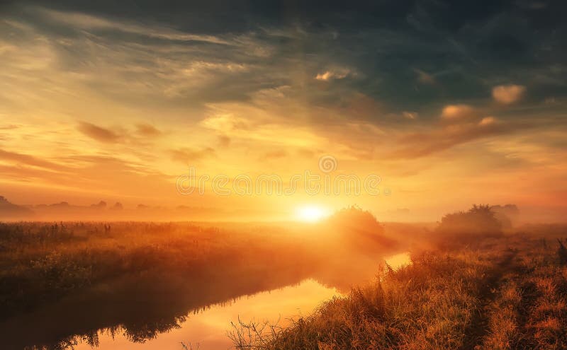 Wonderful dramatic scene. fantastic foggy sunrise over the meadow with colorful clouds on the sky.