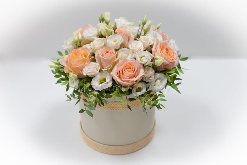 Wonderful flower arrangement in a hat box on a light background