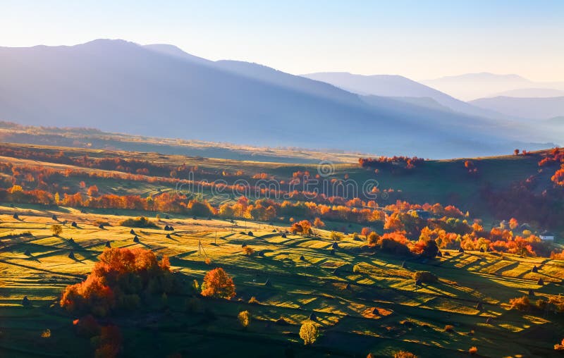 Wonderful landscapes with cities with fields and haystacks. Fruit trees with colored leaves. High mountains.