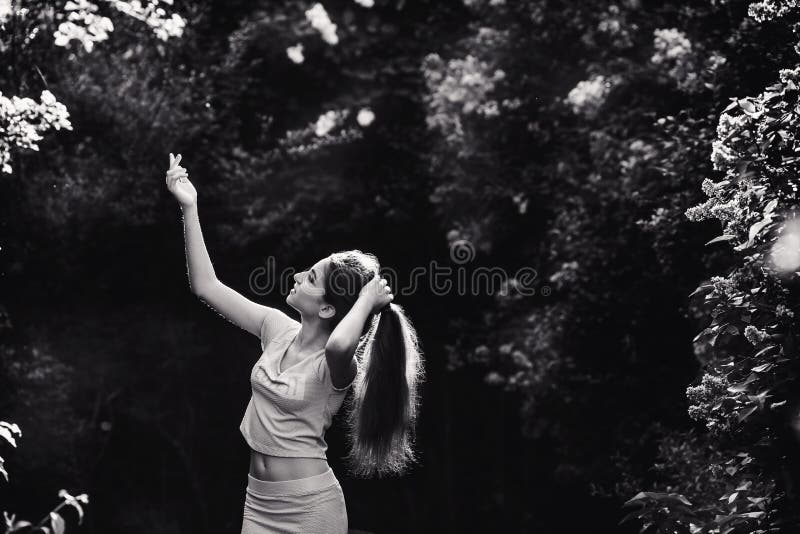 Wonderful spring. A beautiful young girl enjoys nature and sunlight among the blossoming lilac. royalty free stock image Wonderful spring. A beautiful young girl enjoys nature and sunlight among the blossoming lilac. royalty free stock image