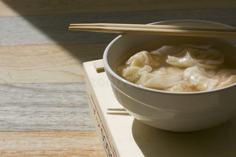 Wonton nouvellement fabriqué avec des baguettes sur la cuvette blanche photos libres de droits Wonton nouvellement fabriqué avec des baguettes sur la cuvette blanche photos libres de droits